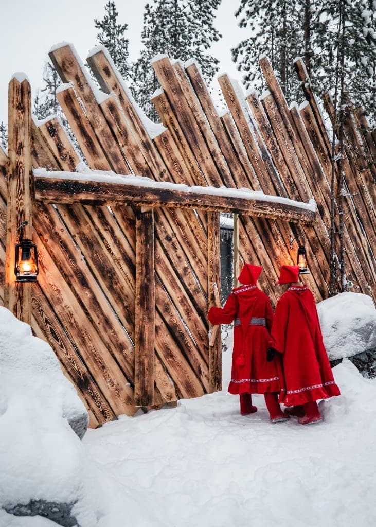 Two elves opening the wooden gate of Santa's secret forest