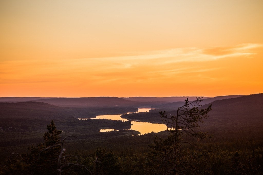 Midnight sun glowing over the Ounasjoki river seen from a fell