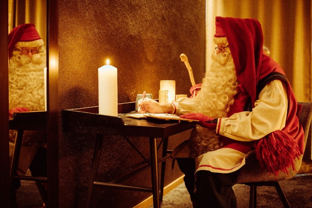 Santa Claus writing letters by candlelight