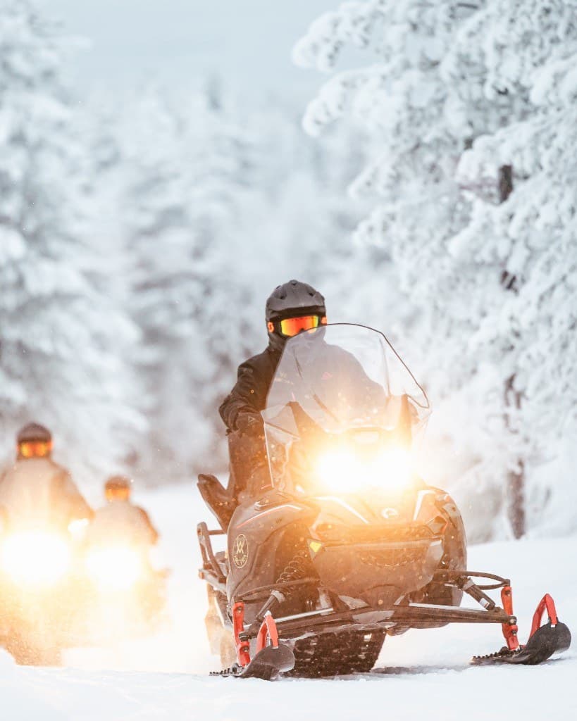 A reindeer herder walking the family sleigh through the snowy forest