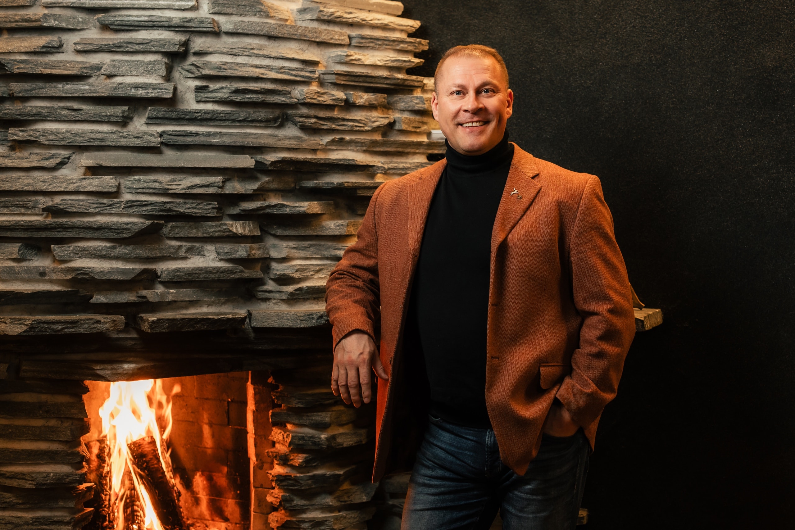 Henry Hynynen by the fireplace of a Lapland lodge